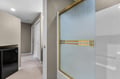 Step into your private bathroom featuring a spacious glass-enclosed shower with elegant gold fixtures and pristine white tiles.