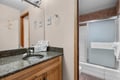 Step into your private bathroom, where fresh towels and thoughtful amenities await. The granite vanity and warm wood tones create a welcoming retreat after a day of adventure.