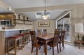 Gather around the elegant dining table for memorable meals, with natural light streaming through skylights and mountain views beyond.