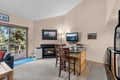 Cozy up by the fireplace in your open-plan living and dining space with kitchen island seating. Step out onto the balcony for peaceful forest views and fresh mountain air.