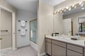 Main Level Primary King Suite Bathroom. Unwind in your spacious bathroom with Hollywood-style vanity lighting and glass-enclosed shower, complete with plush towels and premium amenities.