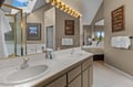 Upstairs Primary Dual Sinks. Your spacious bathroom features dual sinks and glamorous lighting, with natural light streaming through the skylight above.