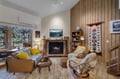 Cozy up in your personal retreat with a crackling fireplace, plush seating, and warm wood accents. Sunlight streams through large windows, while unique touches like vintage ski décor add mountain charm.