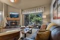 Sink into the plush sofa as the fireplace crackles nearby, warming your space with a cozy glow. Beyond the glass doors, your private balcony overlooks lush greenery—the perfect spot to unwind and breathe in the fresh mountain air.