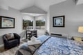 Your bright bedroom offers a cozy work nook by the window, with plush bedding and a peaceful view that invites restful mornings and productive afternoons.