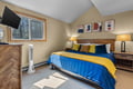 Slip into this cozy bedroom where sunlight warms your space and modern abstract art adds a splash of color to your mountain retreat.
