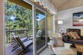 Step into your cozy living room where natural light pours through sliding doors leading to your private balcony. Sink into comfortable seating and enjoy serene forest views framed by towering pines.