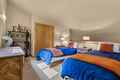 Sink into plush beds dressed in vibrant blue and warm orange, with soft lighting casting a peaceful glow across your private retreat.