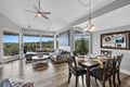 Relax in your light-filled living and dining area with soaring ceilings and sweeping forest views. Unwind on the plush sectional or gather around the elegant dining table—this space invites you to feel right at home.