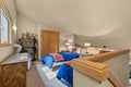 Rest easy in your bright attic bedroom with twin beds wrapped in bold blue and coral linens, complete with thoughtful lighting and ample storage for all your belongings.