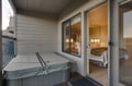 Step through the glass doors to your private balcony and sink into the hot tub beneath the covered overhang. Inside, a cozy bedroom with soft lighting awaits your return.