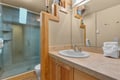 Step into your private bathroom featuring warm wood cabinetry, a spacious glass-enclosed shower, and plush towels waiting for you.
